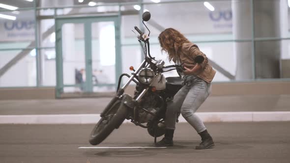 Beautiful Young Woman Riding an Old Cafe Racer Motorcycle on Street