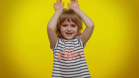 Funny Lovely Teen Kid Child Girl Smiling Friendly and Doing Bunny Ears Gesture on Head Having Fun