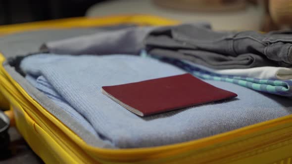 A Young Woman is Packing Her Suitcase