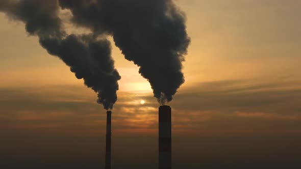 Air pollution. clouds of smoke coming from the chimneys of the plant with beautiful golden yellow li