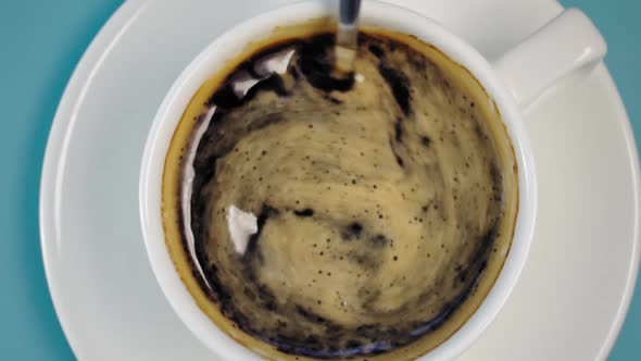 Stirring Black Coffee with Spoon