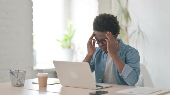 Young African Man Having Headache While Working on Laptop