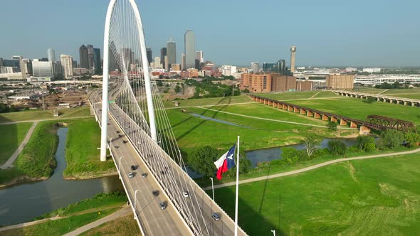 Texas flag and Dallas skyline. Bridge over Trinity River during golden hour light. Aerial approach a