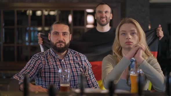 Portrait of Happy Sports Fans Supporting National Team in Pub with German Flag