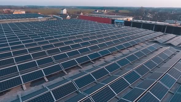 Innovative solar farm at sunset. Photovoltaic panels in rows on the roof of buildings in the country