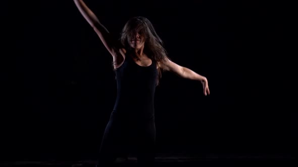 Young Dancer Woman Is Performing Contemporary Dance in Dark Studio, Moving Energetic and