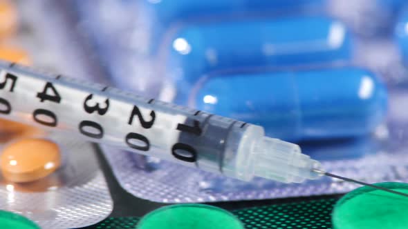 Some Different Contraceptive Pills and Syringe, Close Up, Cam Moves To the Left