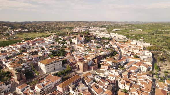 Orbiting shot of  Silves Cathedral and Silves cityscape. Walled fortified town.