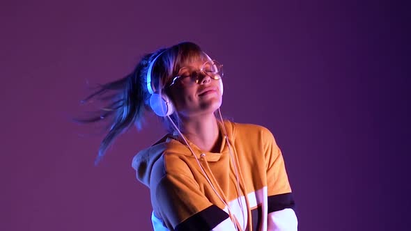 Teen Girl Wear Headphone Listen Music Dancing in Purple Neon Slow Motion