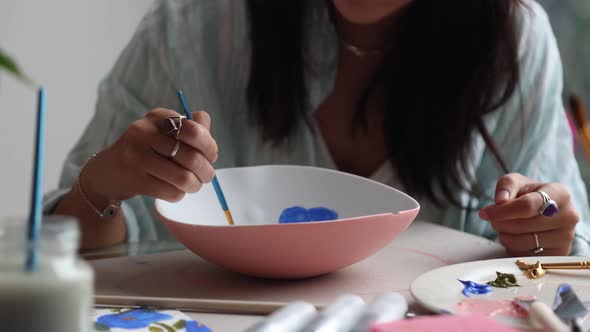 Woman painting plate in studio