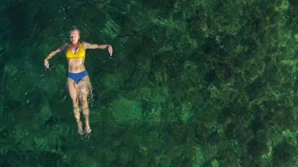 Aerial View of a Girl Swimming in Clear Ocean Water