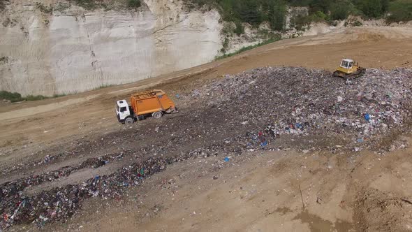 A truck unloading garbage to junkyard. Aerial shot.