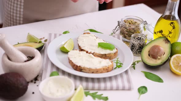 Woman Prepares a Healthy Breakfast or Snack  Soft Cheese Sandwich with Avocado
