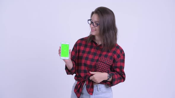 Happy Young Beautiful Hipster Woman Showing Phone and Giving Thumbs Up