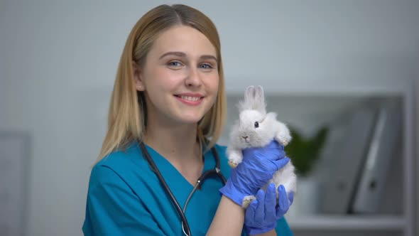 Friendly Female Pet Doctor Holding Bunny Advertisement of Veterinary Clinic