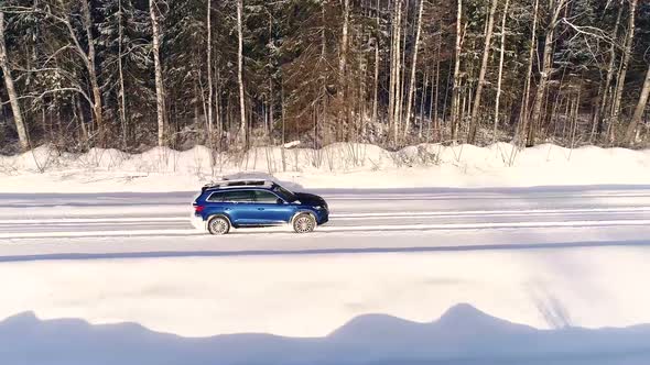 Aerial view of a car driving in the snowy forest in Estonia