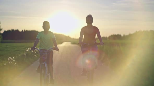 Slow Motion Video of a Family Riding Bicycles in a Park at Sunset