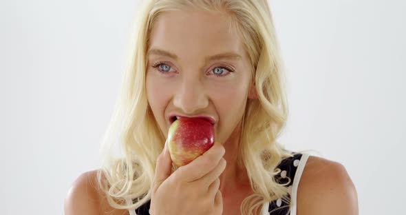 Close-up of beautiful woman eating red apple