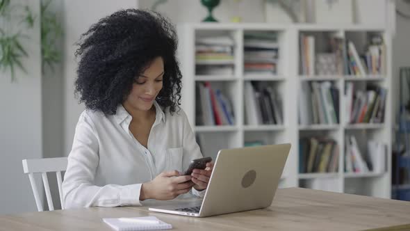 Portrait of a Young African American Woman Texting on a Smartphone