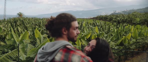A couple admiring the banana trees fields and talking with a friends behind them