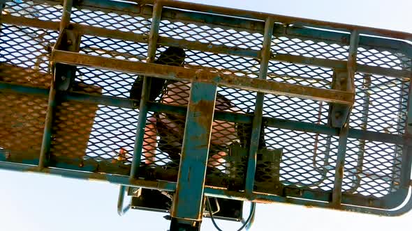 View From Underneath of Worker on Cherry Picker