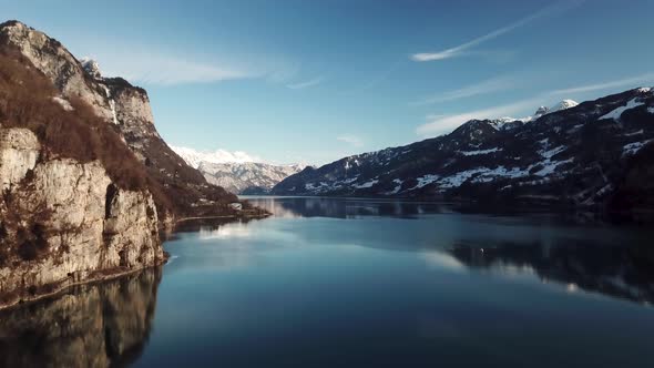 Stunning aerial shot of a cliff on a fjord, mountain lake in Switzerland while winter.