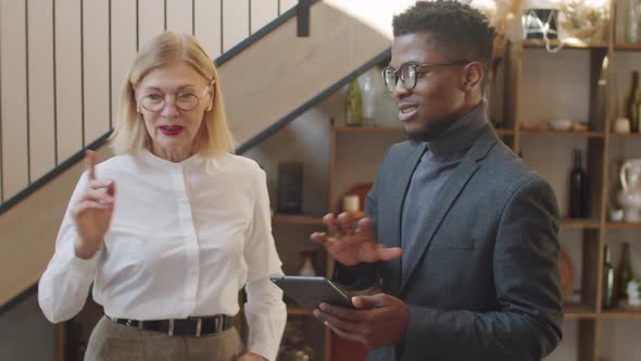 Diverse Male and Female Colleagues Walking with Tablet and Speaking