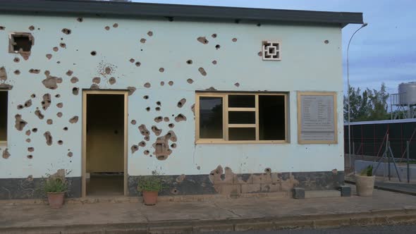 Bullet holes on wall in Kigali Camp