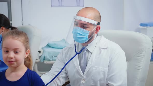 Doctor Giving Girl Checkup in Doctor Office