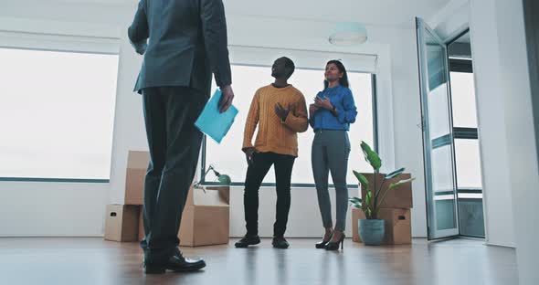 Real estate agent showing young couple apartment on house viewing