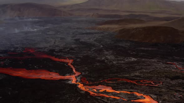 Flowing Lava From A Volcanic Eruption At Dusk. - Aerial Orbiting Shot