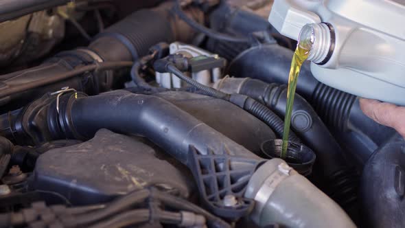 Car Mechanic Pouring New Oil To Engine 2