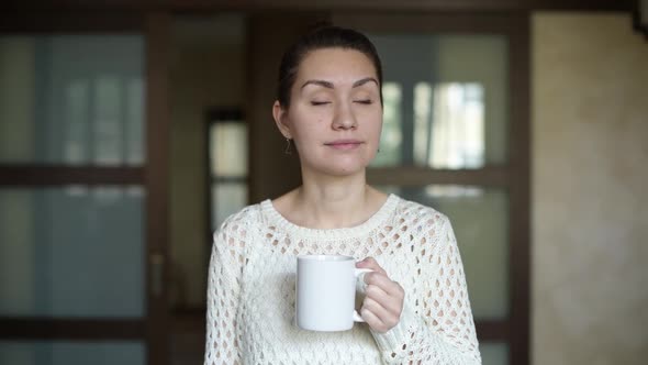 smiling girl looks around and pours red wine into a coffee cup