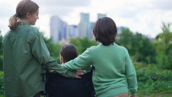 Back View Positive Caucasian Children Talking Pointing at Urban City Supporting Disabled Friend in