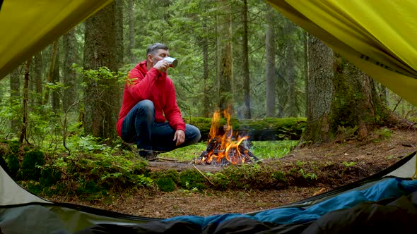 Bearded Man Tourist Near the Fire in a Beautiful Forest