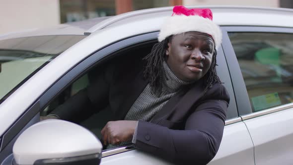 Black Man with Santa Hat Looking Through the Widow of His Car