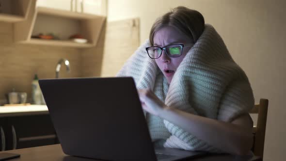 Sick Girl Working From Home on the Laptop, Tied a Scarf and Coughs