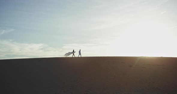 Beautiful Couple Walking Through the Large Beach