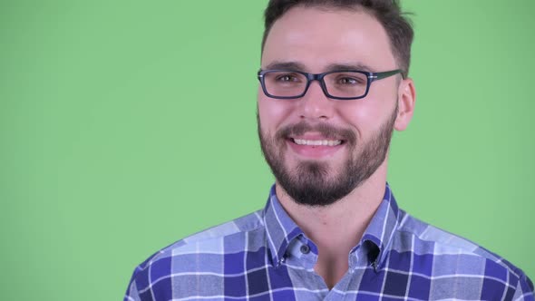 Face of Happy Young Bearded Hipster Man Thinking