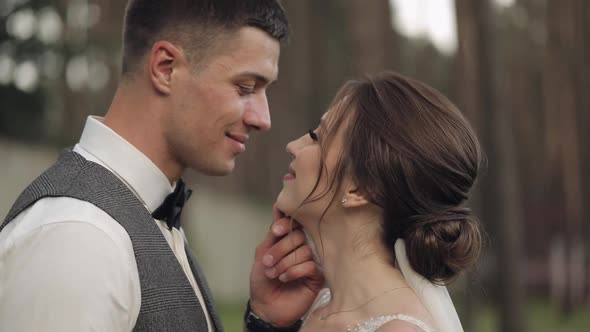 Newlyweds Caucasian Groom with Bride Walking Embracing Hugs in Park Wedding Couple