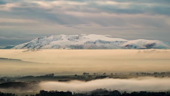 Mist cloaks Cumbria's Eden Valley in a beautiful winters evening scene, with the snow-covered North