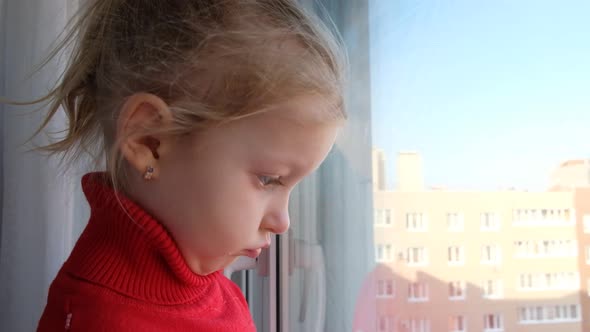 Little Sad Girl Looking Out of the Window