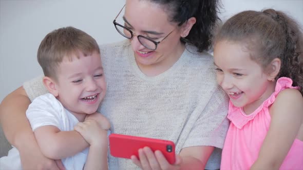 Happy Family,mom and Cute Little Kids,mother Playing with Children at Home Relaxing Use a Smartphone