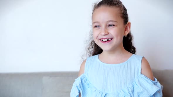 Portrait Funny Little Girl Smiling Chil Looking at Camera Are Sitting on the Couch at Home, Cute Kid