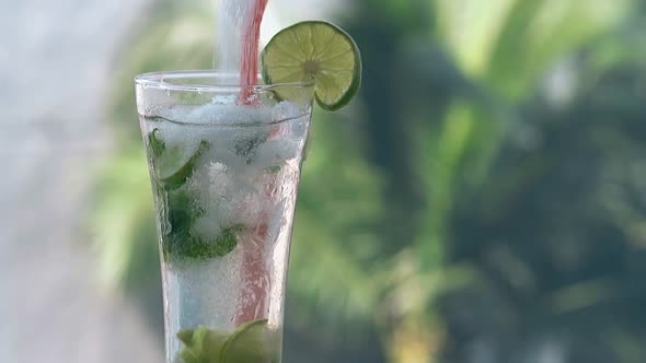 Sugar Pours Into Glass with Mojito Cocktail and Lime Slice