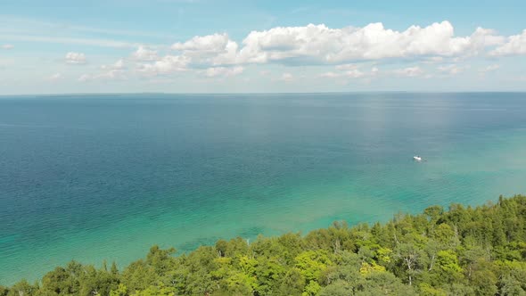 Aerial view of Mackinac Island State Park showing a boat in the crystal clear waters of a highly vis