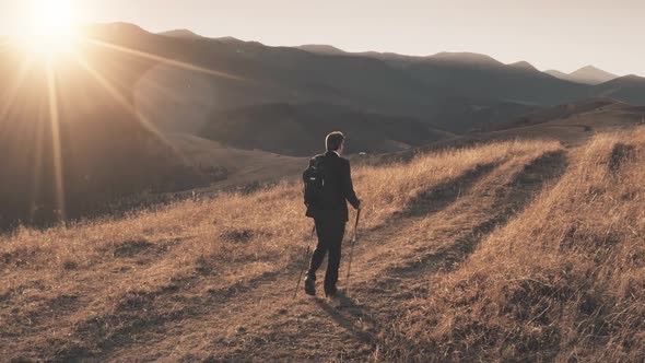 Aerial Man Climbs Trail Mountains at Sunrise