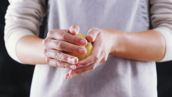 Woman molding a dough ball