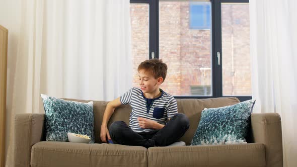 Boy with Popcorn Watching Tv at Home