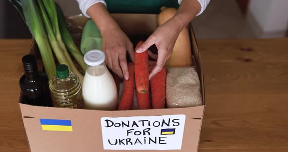 Volunteer preparing food box for ukrainian war refugees